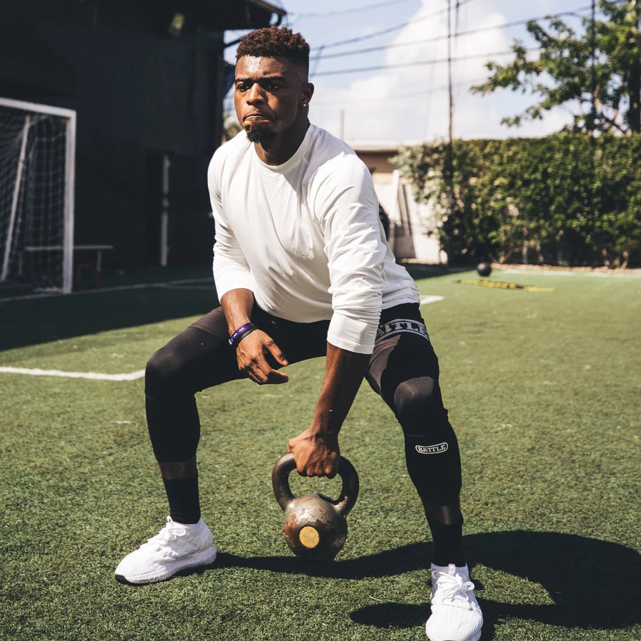 man doing squats with kettlebell