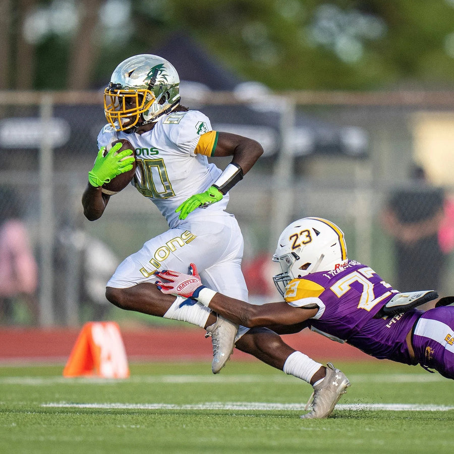 Boy breaking tackle in football game