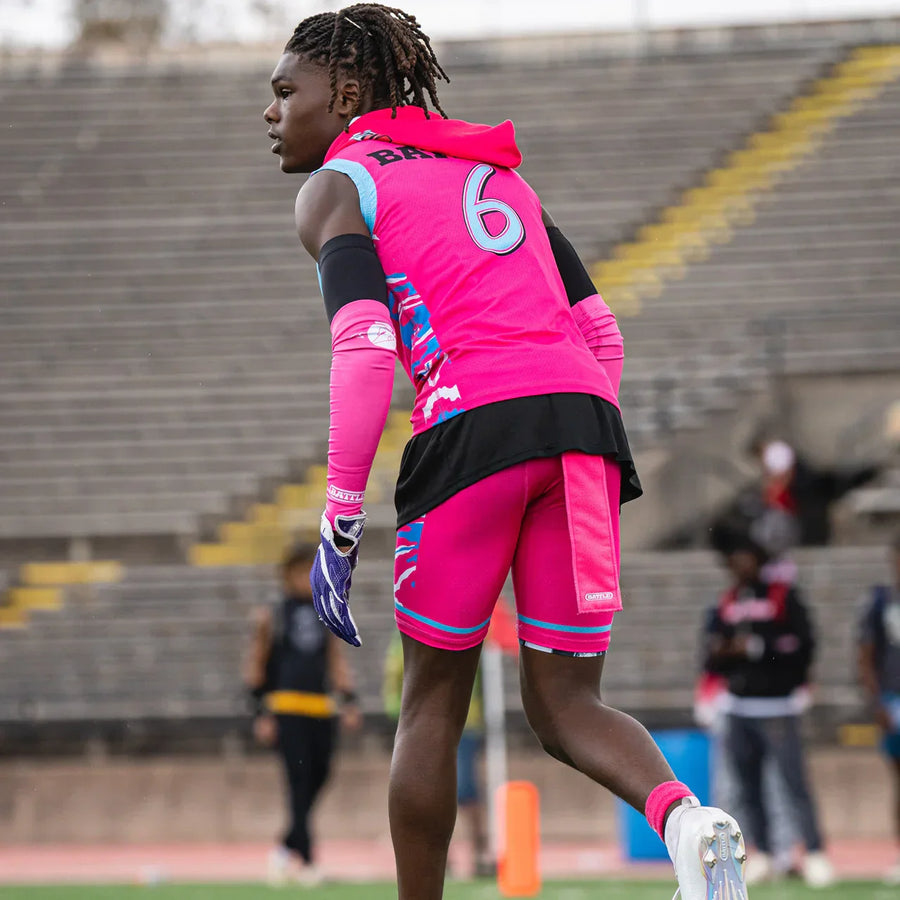 Football player in bright pink outfit with pink towel
