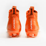 A pair of bright orange football cleats with white 'BATTLE', displayed on a clean white background.