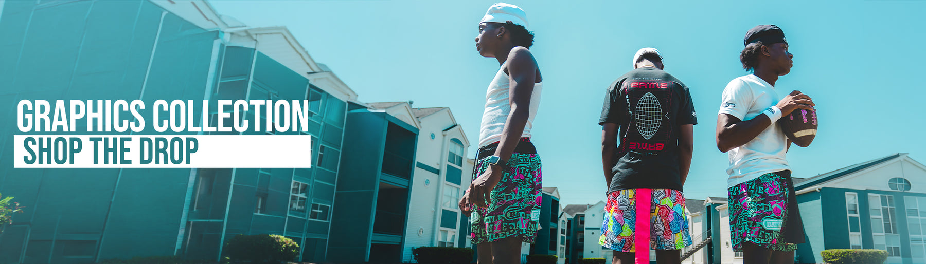 Three young men wearing colorful athletic shorts and t-shirts stand outdoors in front of modern buildings under a bright blue sky. Large text on the left reads 'GRAPHICS COLLECTION SHOP THE DROP'.