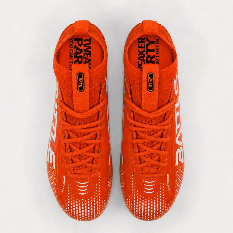 A pair of cleats shown from a top-down view on a light gray background. The shoes feature white branding on the sides and black text on the tongue.